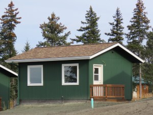 Front view of Peggy's Cabin, a green cabin with white trim.