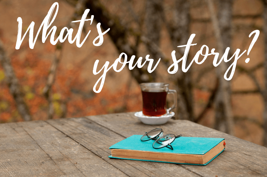 A cup of tea and a book on an autumn picnic table with the heading "What's Your Story?"